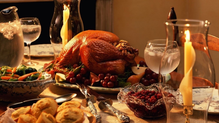 Thanksgiving dinner table with turkey cranberries and candles