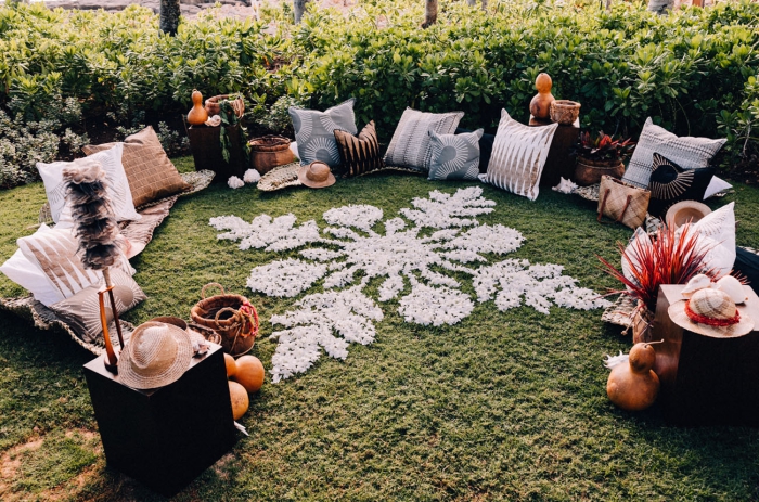 Outdoor setting on a green lawn with pillows and a snowflake decoration