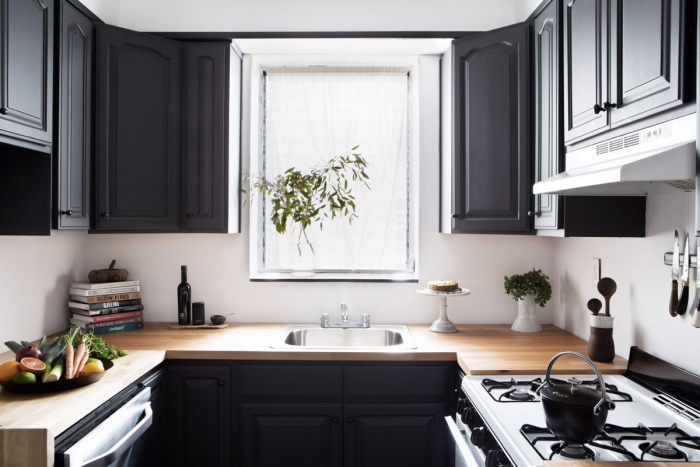 dark u-shaped kitchen with a wooden countertop