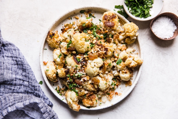 baked cauliflower in a plate with salt and green spices