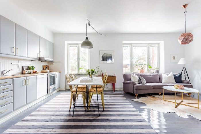 Grey and white airy light living area with kitchen dining table and sofa 