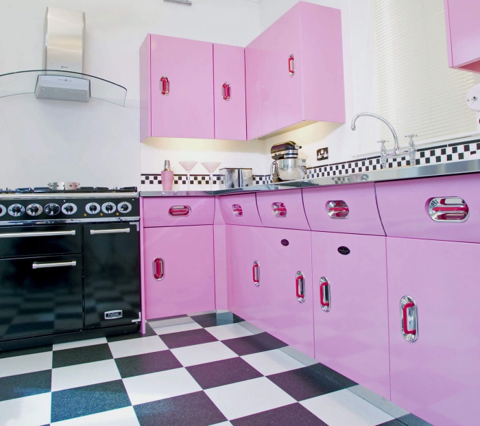 bright modern kitchen in bright pink and black with metallic countertop