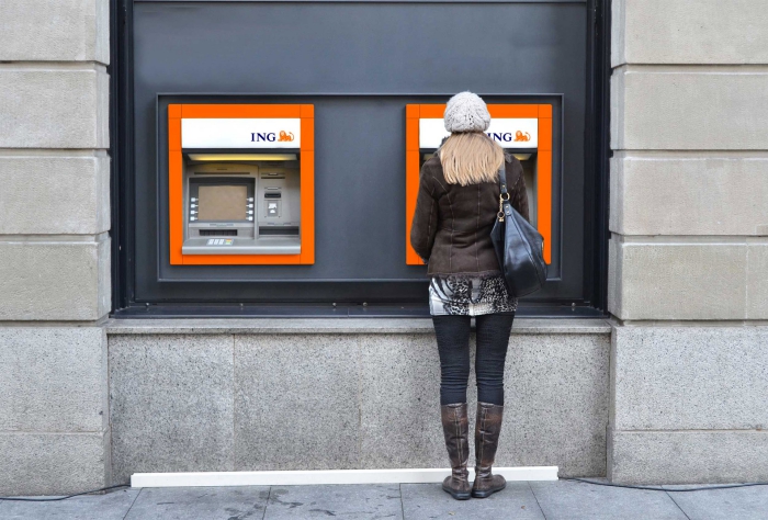 Woman with a hat in front of two ING ATMS money withdrawal