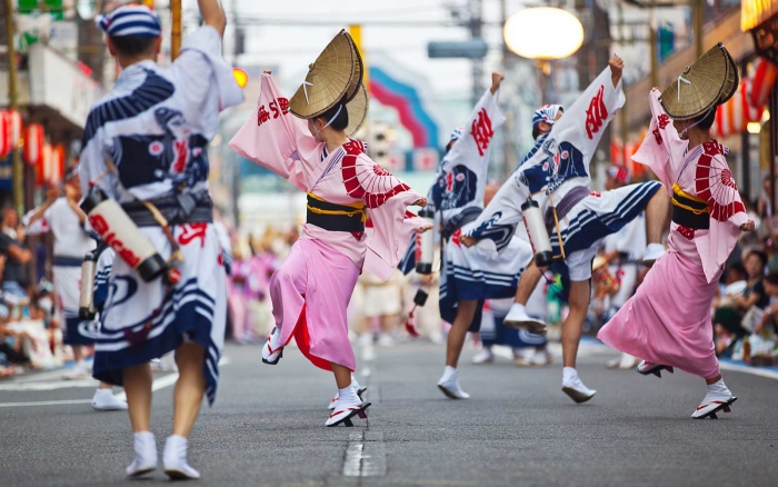 Japanese girls in pink and white dancing at one of their big festivals 