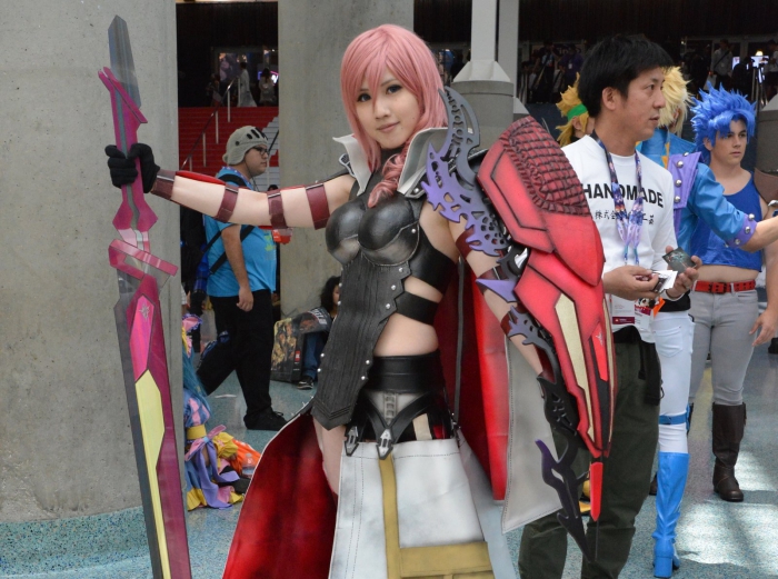 real girl with manga costume, pink hair and large sword 