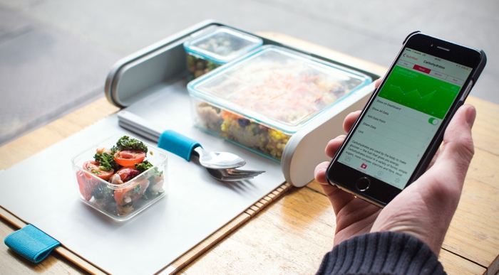 Modern lunchbox for adults man with a phone eating lunch from a lunch kit