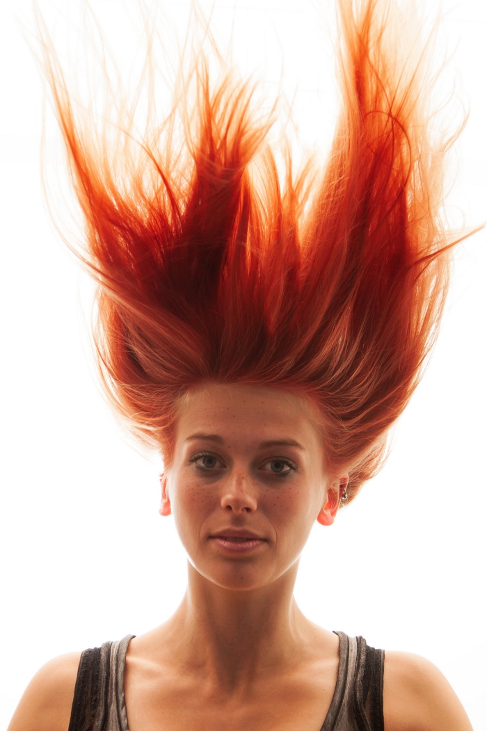 woman with red hair color hair flying up 