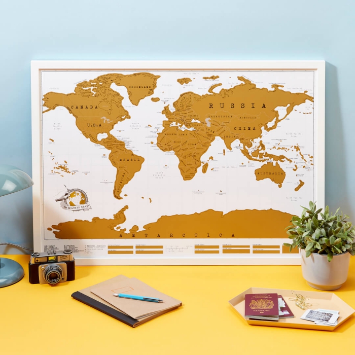 unique travel gifts ideas scratch map on a desk with photo camera passports notebooks