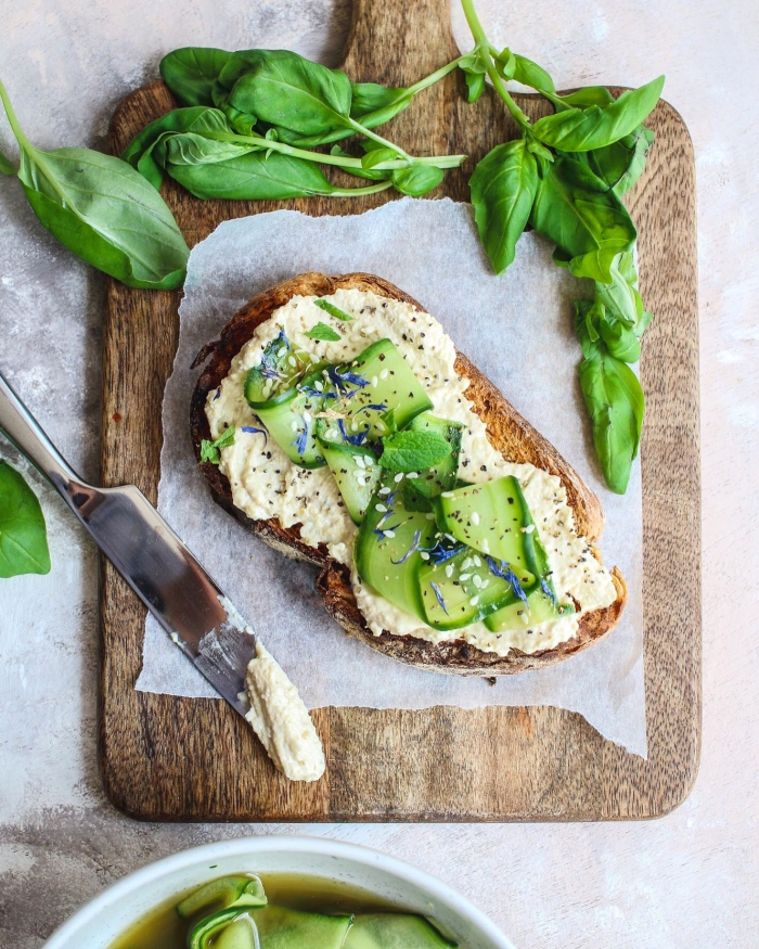 vegan hummus toast with cucumber and leafy greens spinach