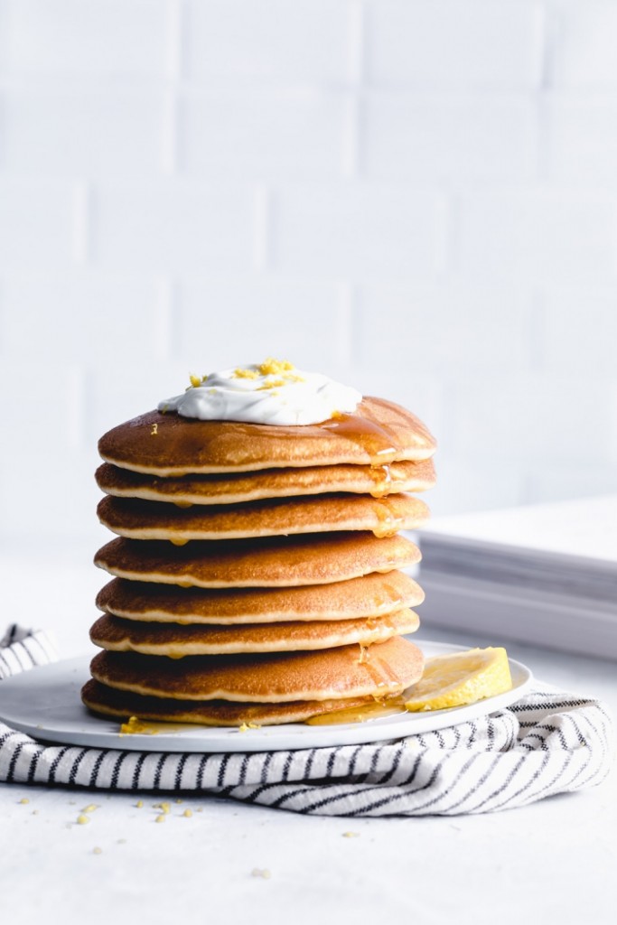 vegan breakfast stack of pancakes with cream and maple syrup