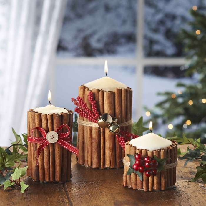 Christmas Decorative Candles with cinnamon sticks and berries window in the background