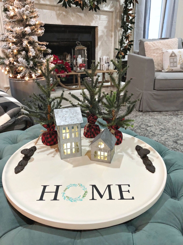 Large white serving tray with christmas decor lanterns and small trees