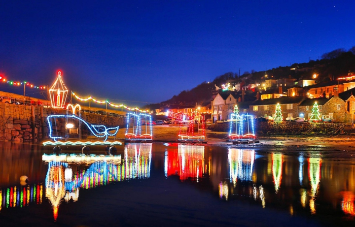 Halfpenny Christmas getaway ideas Cornwall lake with floating light decorations town in the background