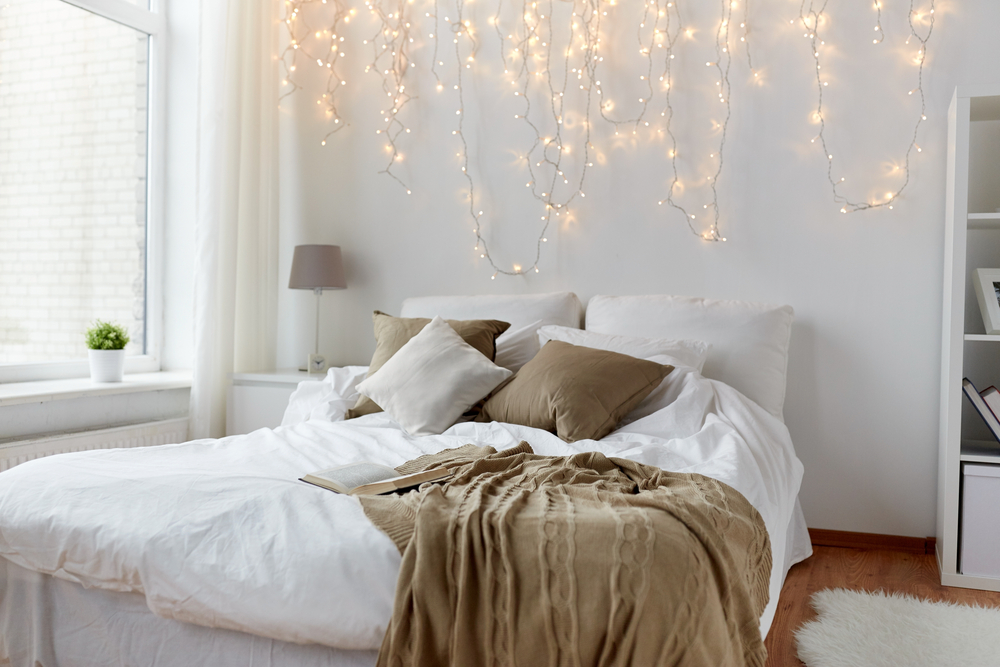 White bedroom with lights above king bed
