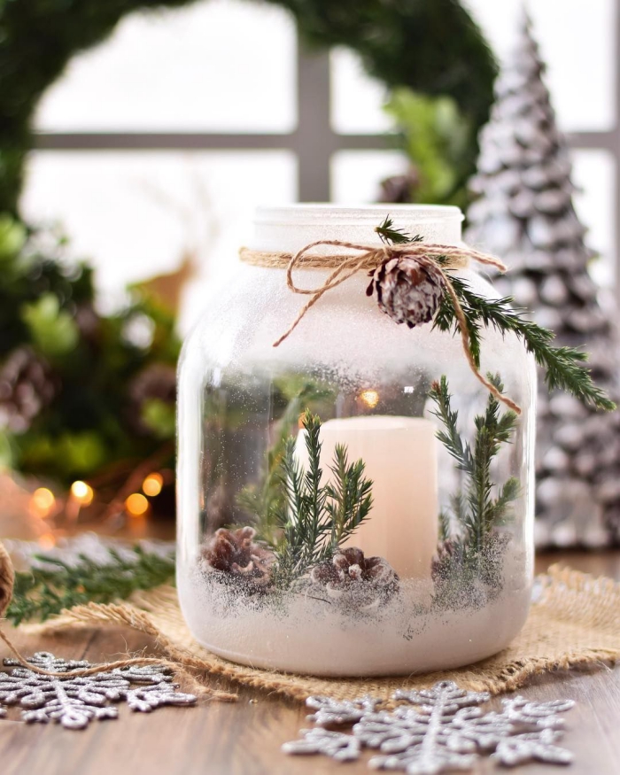 Spray painted glass jar with a candle pinecones and green branches