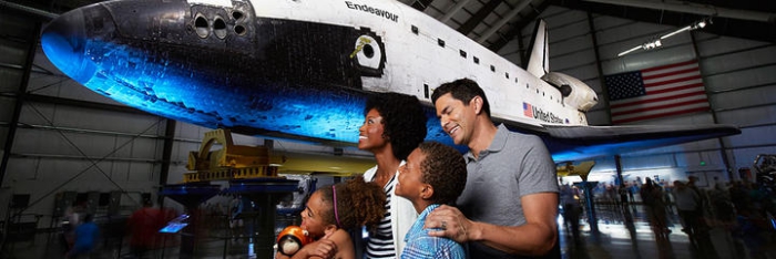 Family with kids in a museum looking at a plane