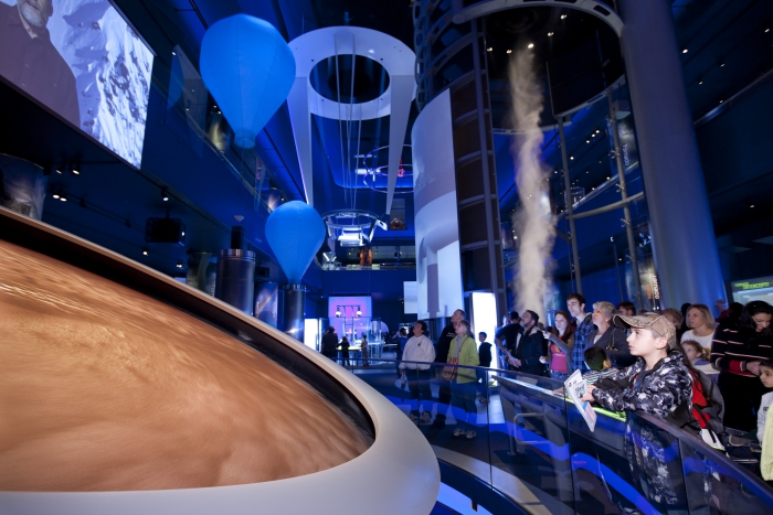 People in a science museum watching the planets stars 