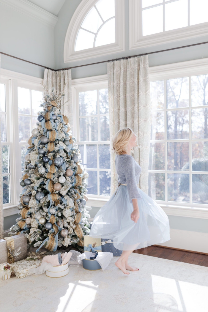 Romantic Blue Christmas decor woman in blue dress big windows light room pastel blue christmas tree