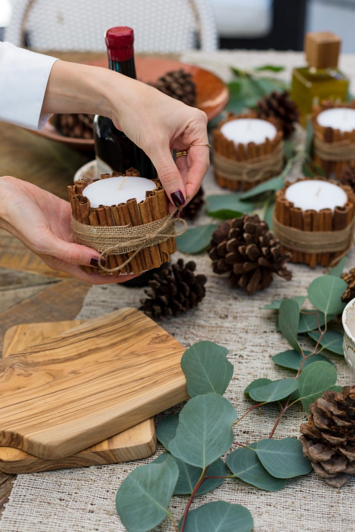 woman cinnamon Christmas table centerpiece diy candle holders pinecones 