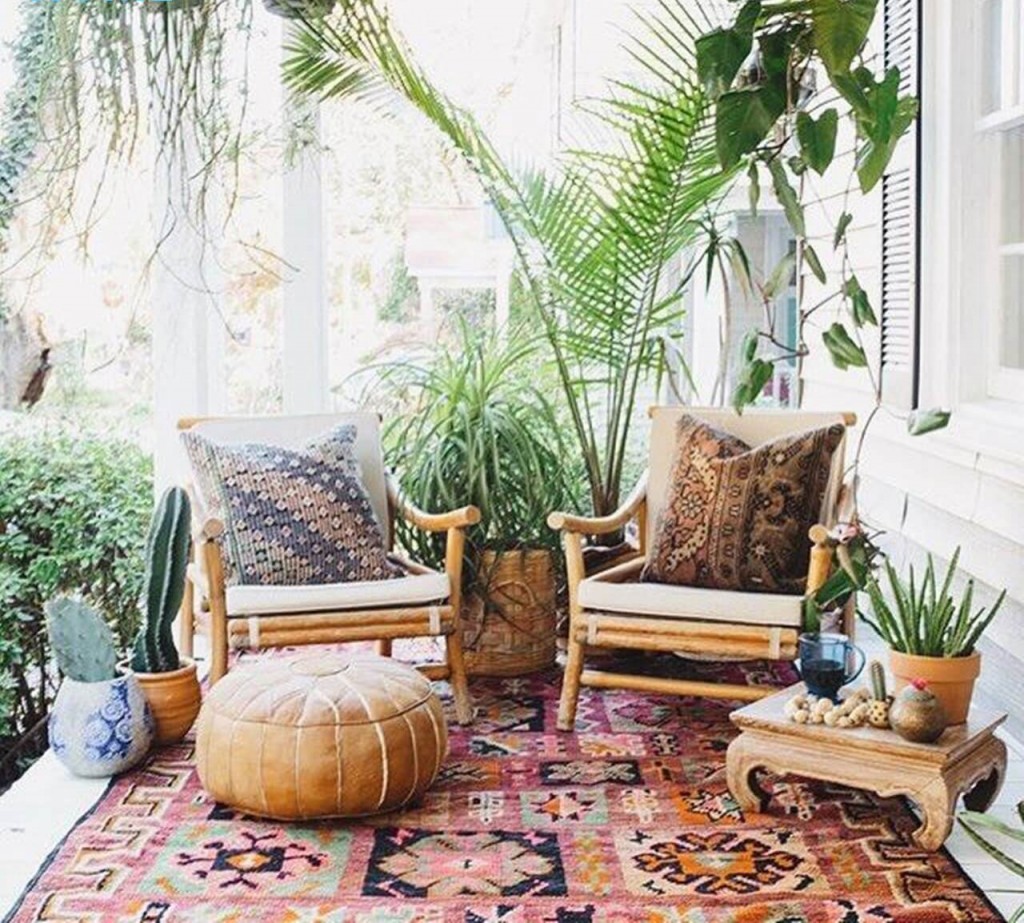 Boho style small patio with ottoman small table cacti greenery two chairs