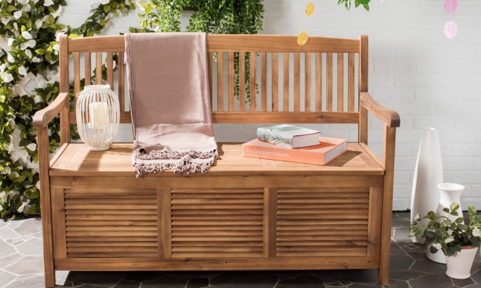 Space saving wooden patio bench with lantern books and blanket