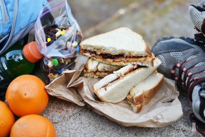 camping food peanut butter sandwich with oranges bottle and snack