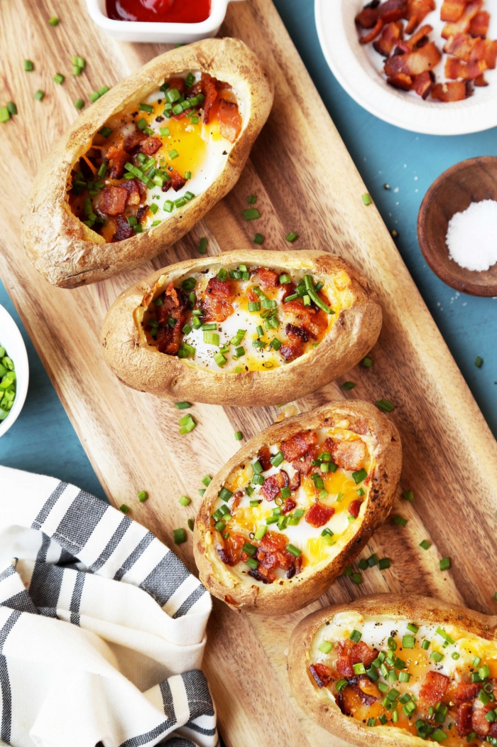 Potato Boats on a wooden board with salt bacon and chopped onion