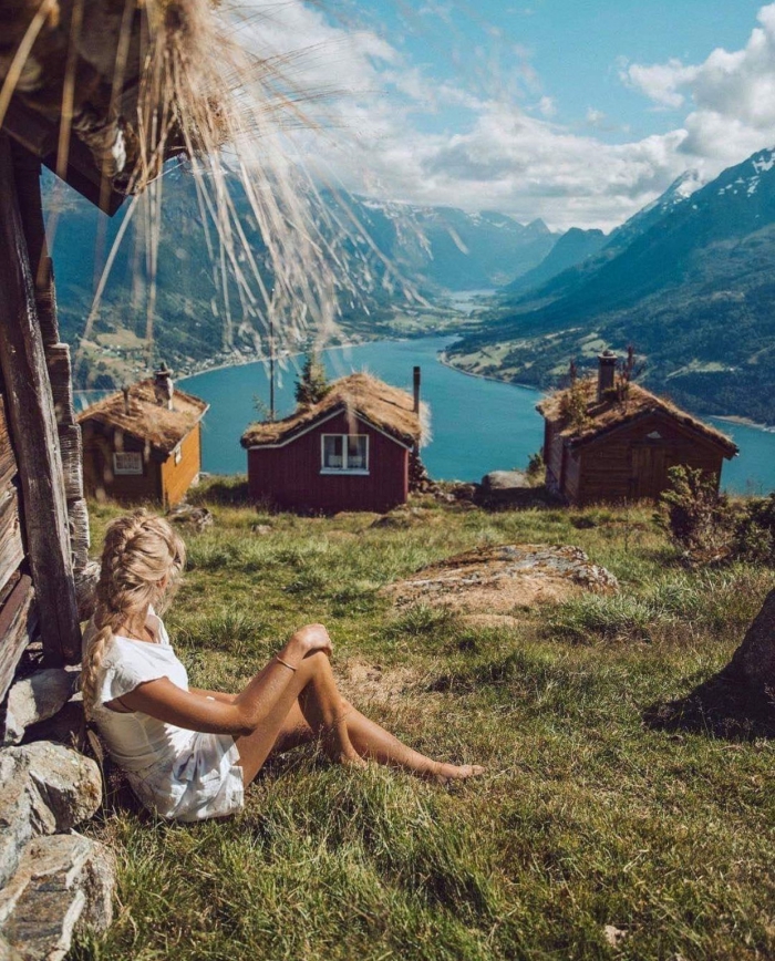 Best Cabins for rent in Norway woman looking at the fjords houses mountain landscape