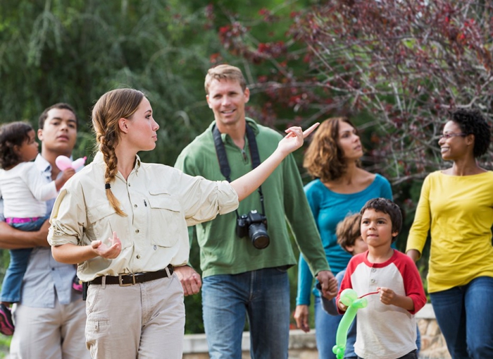 Best travel jobs tour guide woman with a group of tourists showing around