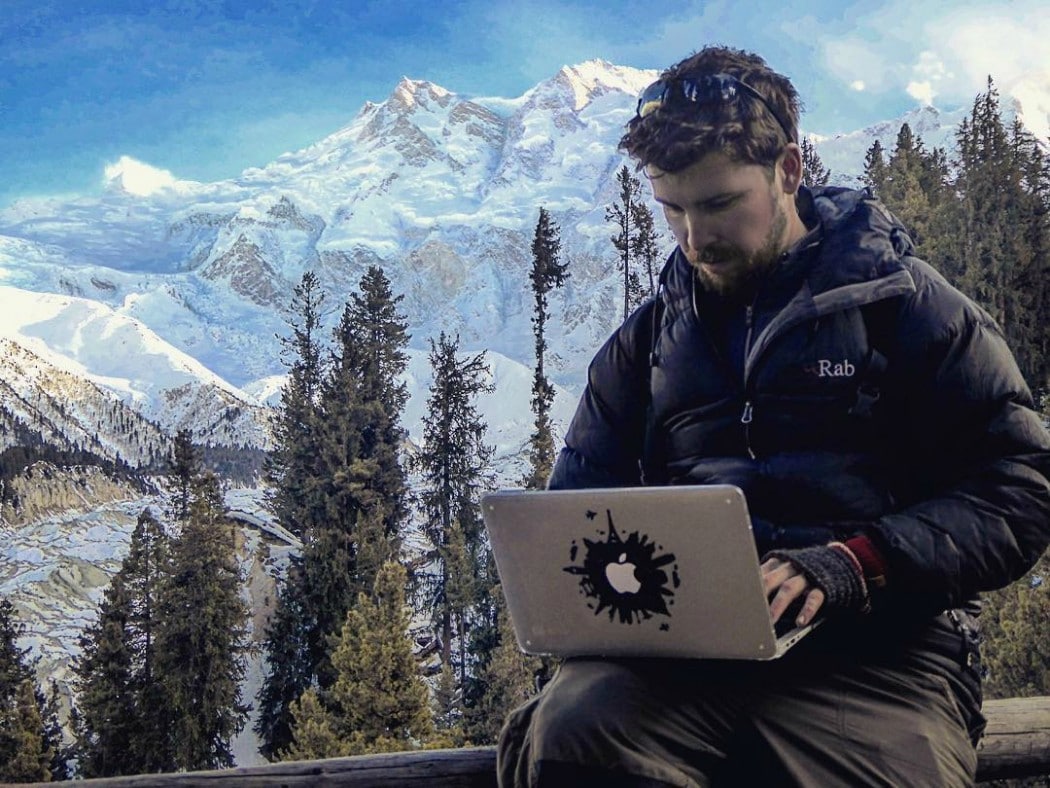 man with his laptop in the mountains software engineer snowy peaks