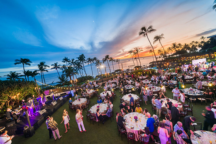 Food and Wine Festival Hawaii outdoor stage people dining tables on a lane palm trees sunset