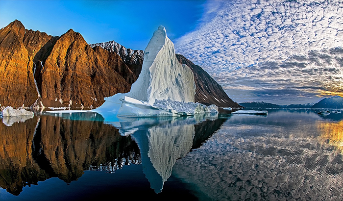 Amazing landscape Greenland iceberg rocky cliffs mirror water clouds