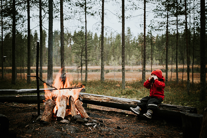 North Europe Nature of Finland child in red jacket around next to a fire forest 