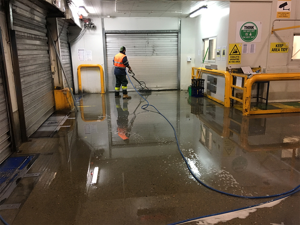 Man washing underground place with a machine