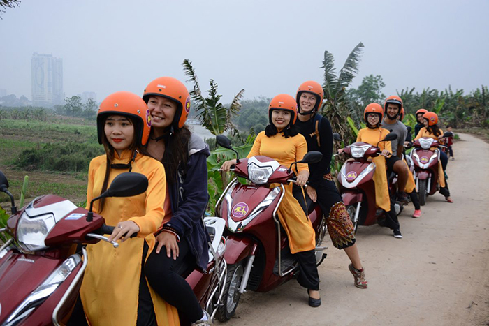 Girls on scooters tourists in Vietnam travel with friends