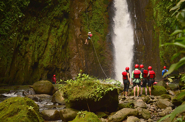Costa Rica waterfall people climbing cave adventurers