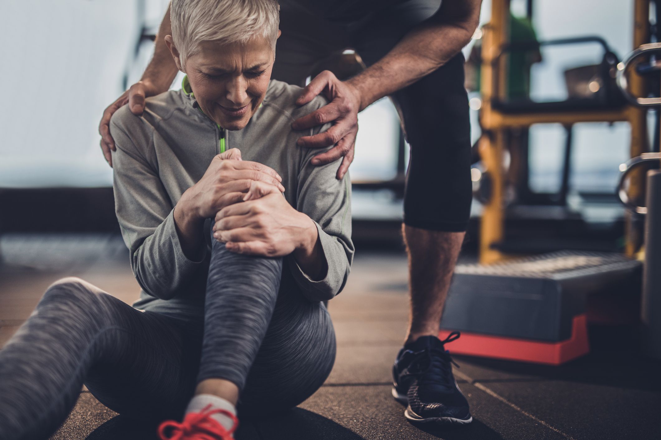 Woman at the gym with training clothes having pain in her leg