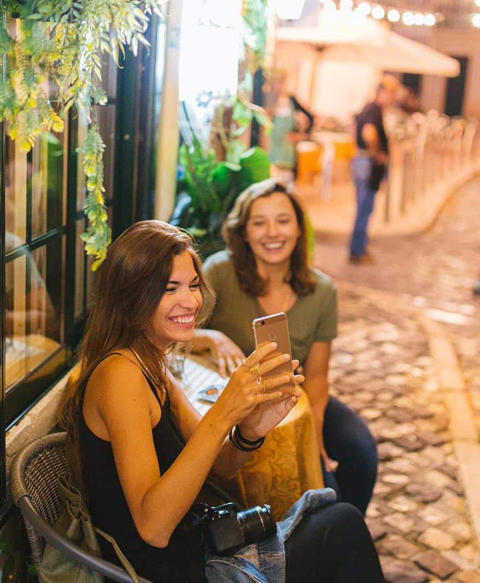 Travel with your best friends Portugal two girls taking a photo dining