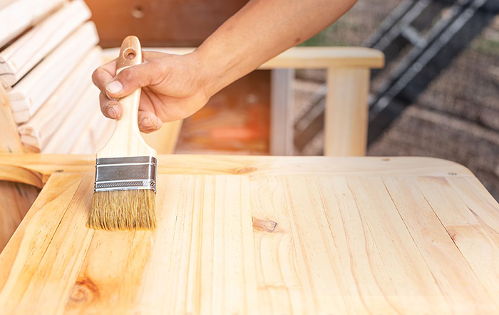 refinishing an old table applying oil to wood with a brush