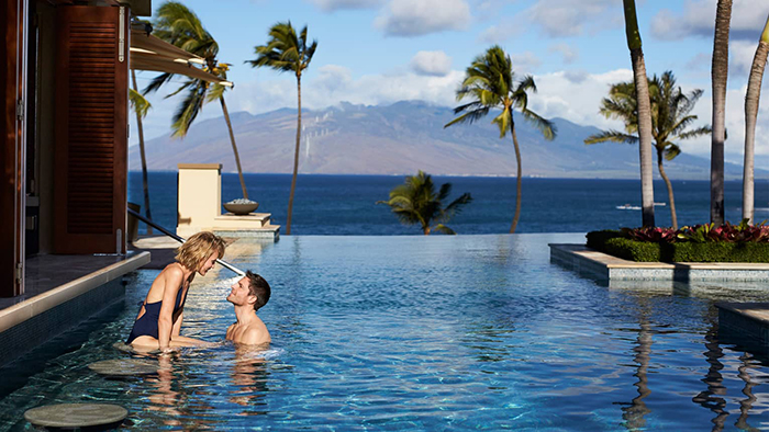 Top Hawaii Resorts Four Seasons Resort Maui outdoor infinity pool couple palm trees