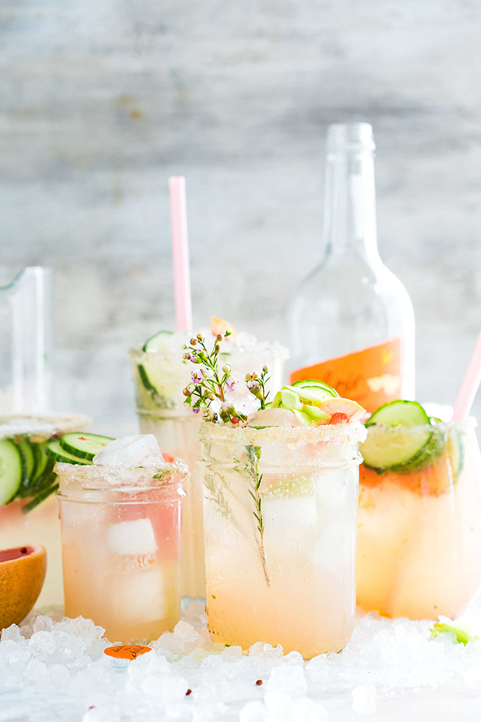 refreshing summer drinks a bottle and glasses with straws with vegetables herbs and ice