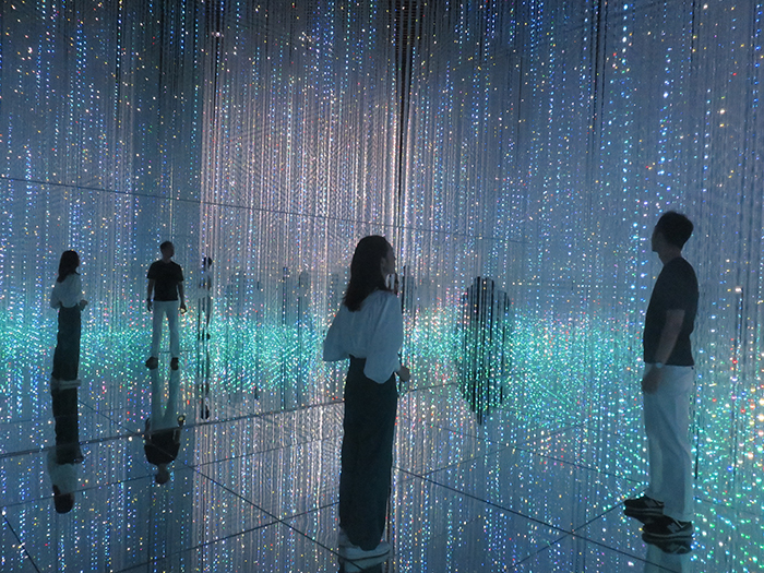 teamlab art exhibition man and woman in a digital reality room full of glitter