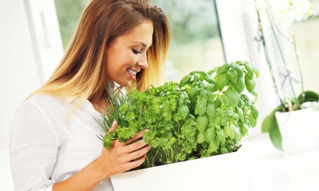 Woman-Growing-Herbs-In-Kitchen