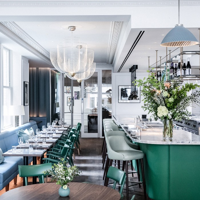 allbright club london bar interior in green and white with fresh flowers and elegant chandeliers