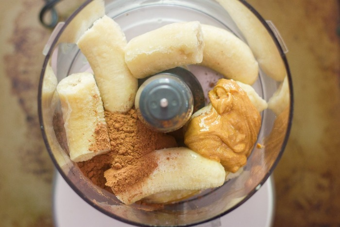 frozen bananas cinnamon and peanut butter in a blender seen from top