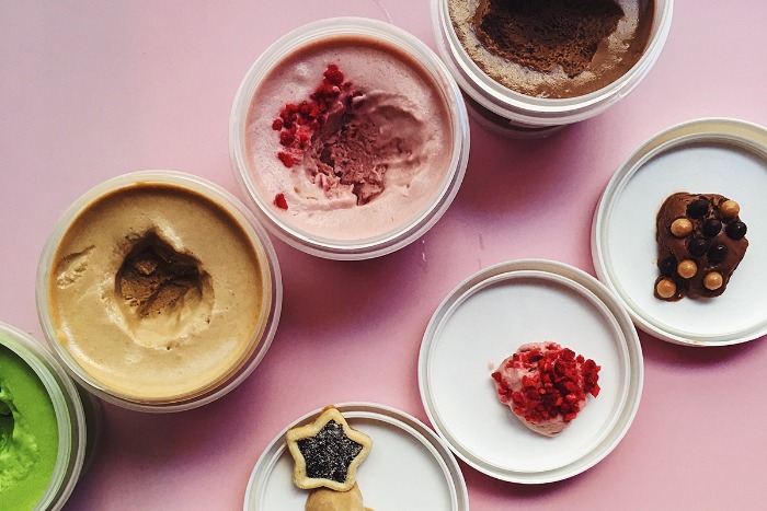 lactose free ice creams in jars different tastes and colors on a pink background