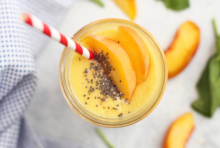 cooling smoothies peach smoothie with a colorful straw on a white table