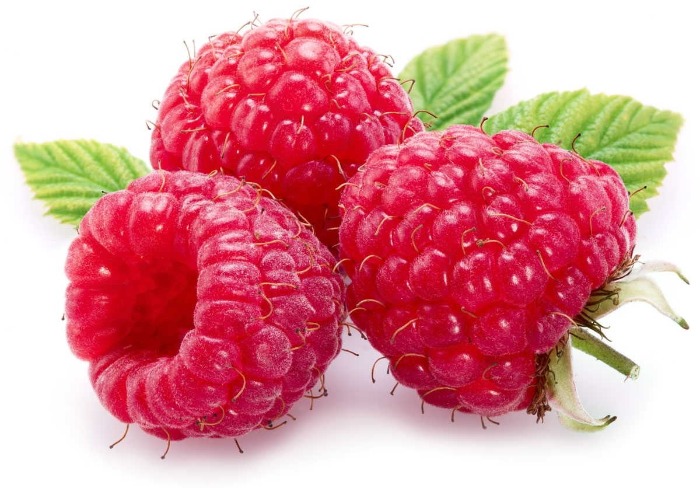 three ripe raspberries with green leaves on a white background