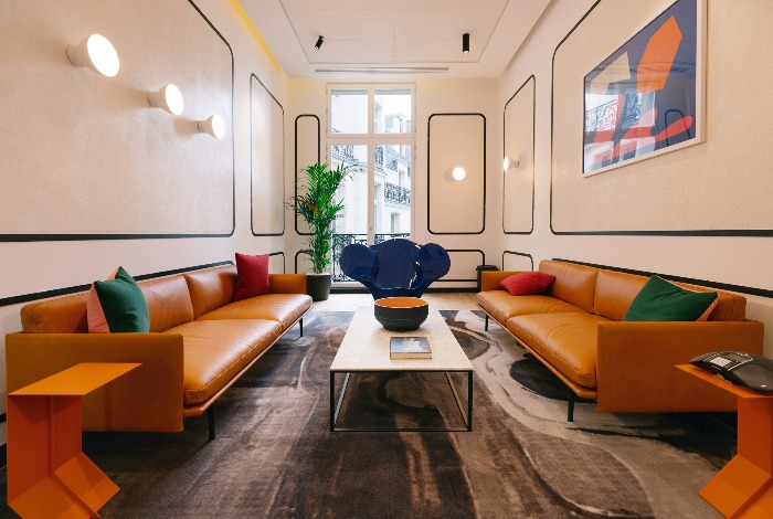 wework campus paris wooden floor leather sofas and bright colorful accents