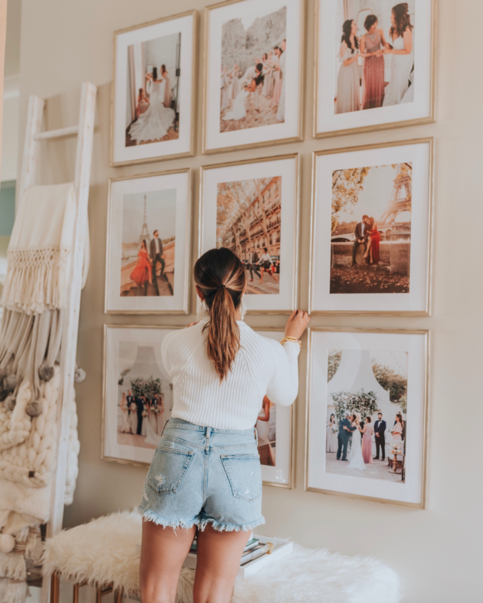 woman arranging posters on the wall on a wall in a room